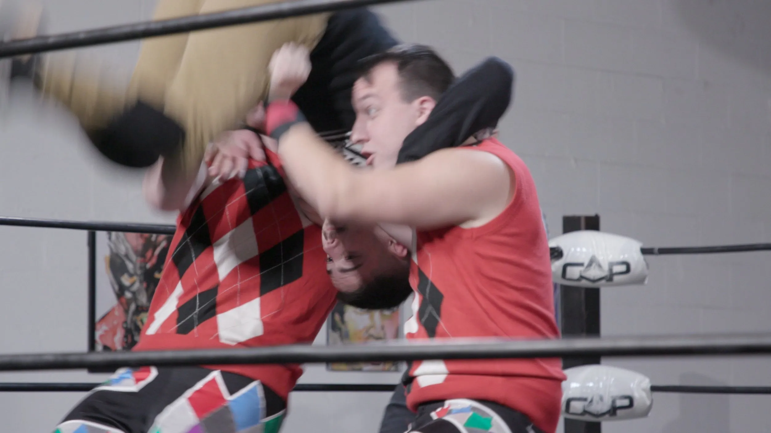 Two wrestlers grapple in the ring during a match